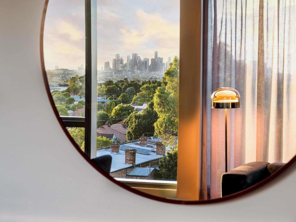 a mirror in a room with a view of a city at Novotel Melbourne Preston in Melbourne