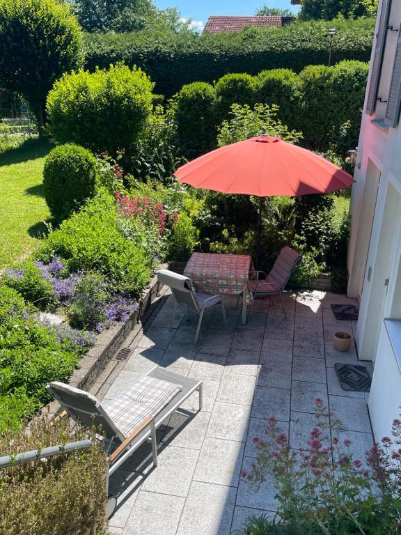a patio with a table and chairs and an umbrella at Ferienwohnung Meding am See in Schondorf am Ammersee