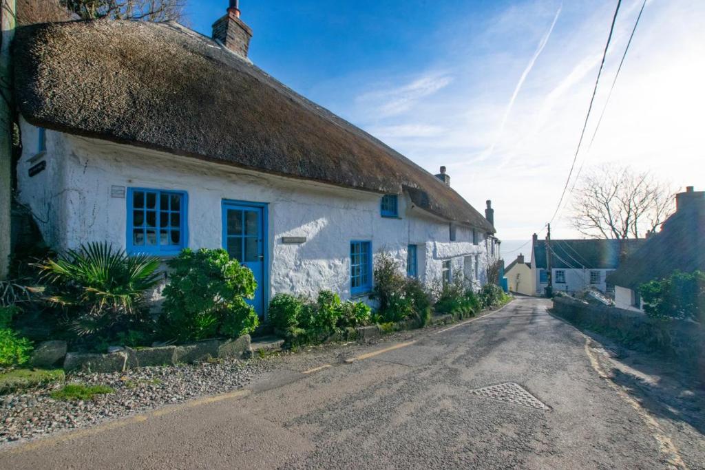 an old white cottage with a thatched roof on a street at 1 Bed in Ruan Minor oc-rencot in Ruan Minor
