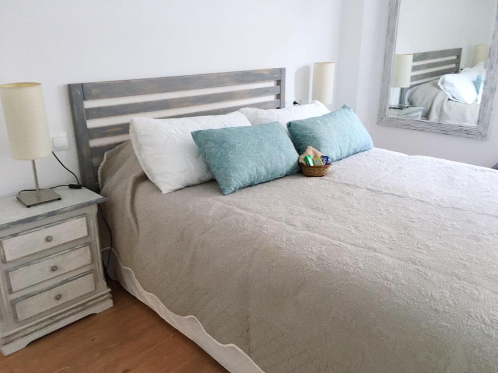 1 dormitorio con 1 cama con 2 almohadas y espejo en Apartamento Rialto, en Málaga
