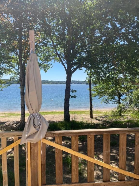 a closed umbrella sitting on a wooden fence near the water at Chez Elisa et Fabien in Canet-de-Salars