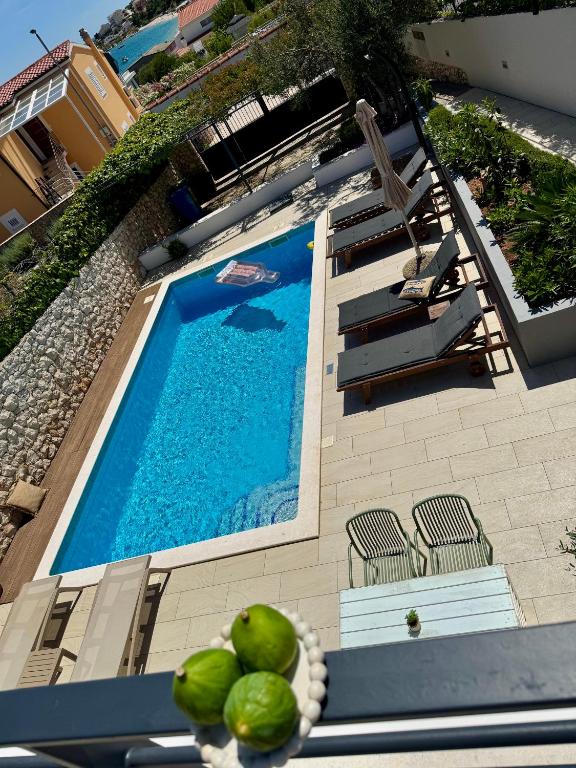 a swimming pool with two chairs and a swimming pool at Holiday Home Vuko in Sevid
