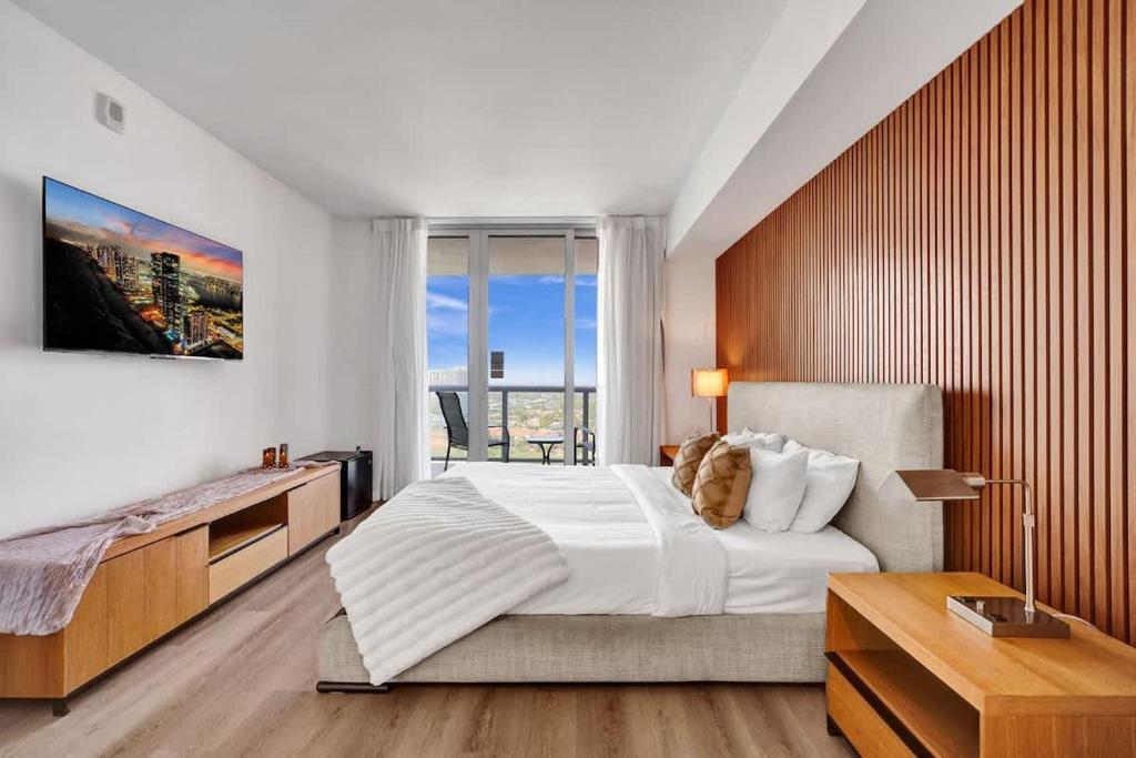 a bedroom with a large bed and a large window at Ocean & Canal View Studio Beach 8 Min Pool 1906 in Hallandale Beach