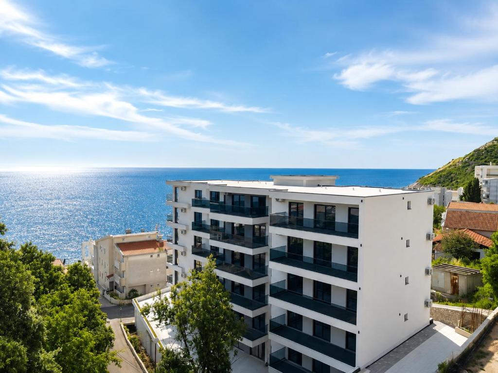 an apartment building with the ocean in the background at Swiss Luxury Appartement in Dobra Voda
