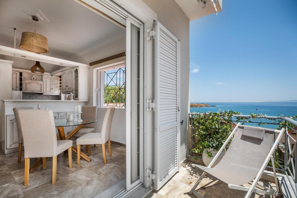 a kitchen and dining room with a view of the ocean at Pallas in Keratea