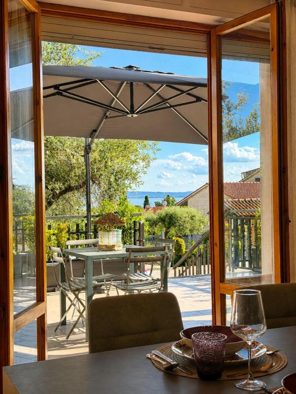 an open patio door with a table and an umbrella at La Perla in Passignano sul Trasimeno