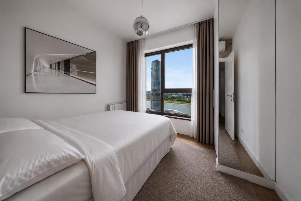 a bedroom with a large bed and a large window at BW Premium One-Bedroom Apartments in Belgrade