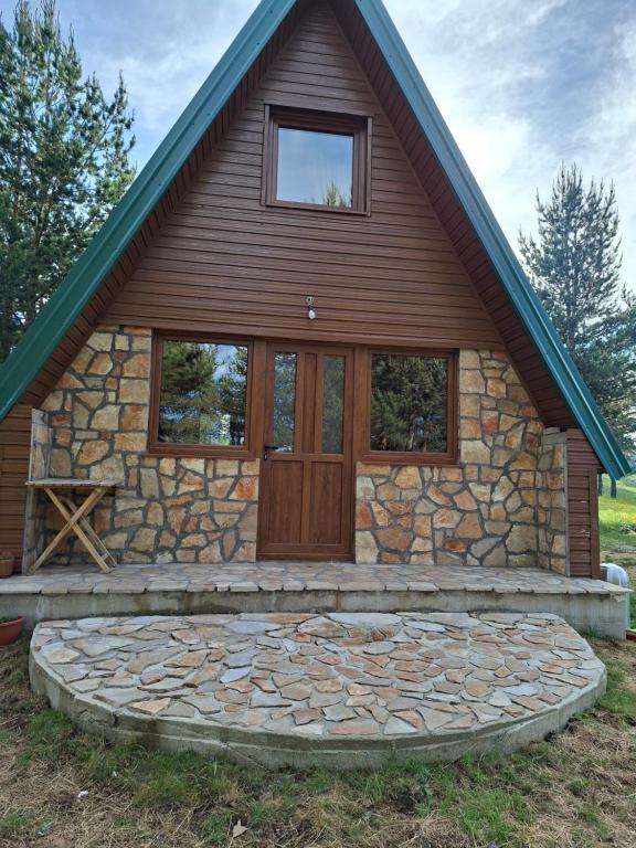 a stone house with a large wooden door at Vikendica Smolovic in Žabljak