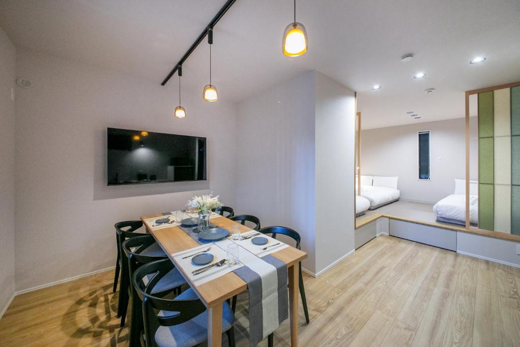 a dining room with a table and a bedroom at T-home彩 in Tokyo