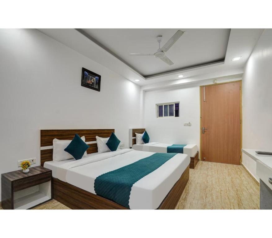 a bedroom with a large white bed with blue pillows at Royal with - Group Name Hotel Double R- comfort stay in Main Bazar New Delhi in New Delhi