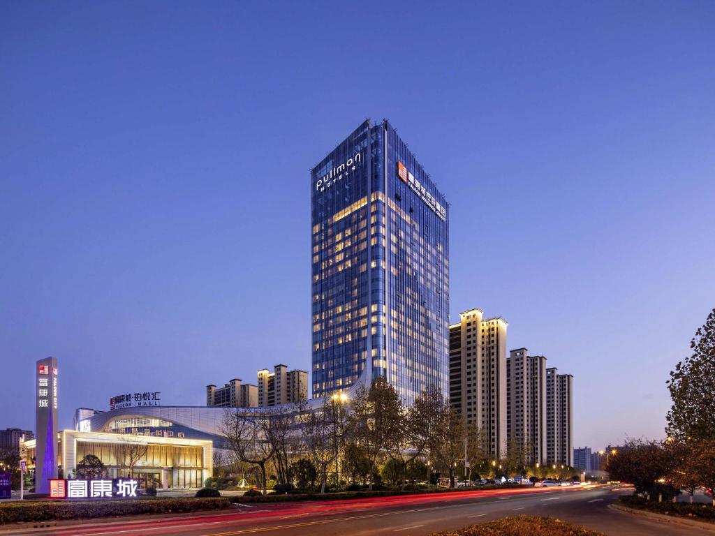 a tall building with lights on in a city at Pullman Huai'an in Huai'an