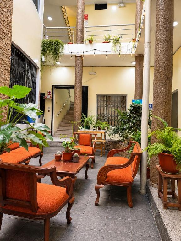 a lobby with tables and chairs and potted plants at Hostal Marín Central - Quito in Quito