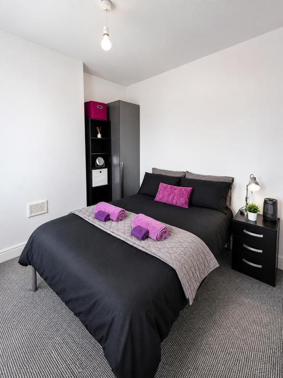 a bedroom with a large black bed with purple pillows at Cinderhouse Highbury Vale in Nottingham