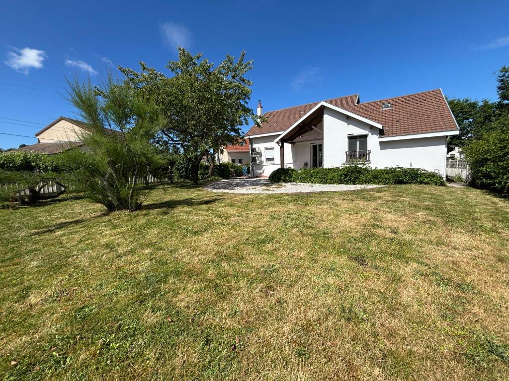 a white house with a tree in a yard at La Maison du Bief in Écuisses