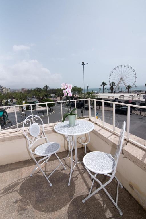 a table and chairs on a balcony with a ferris wheel at Maa Guest House in Civitavecchia