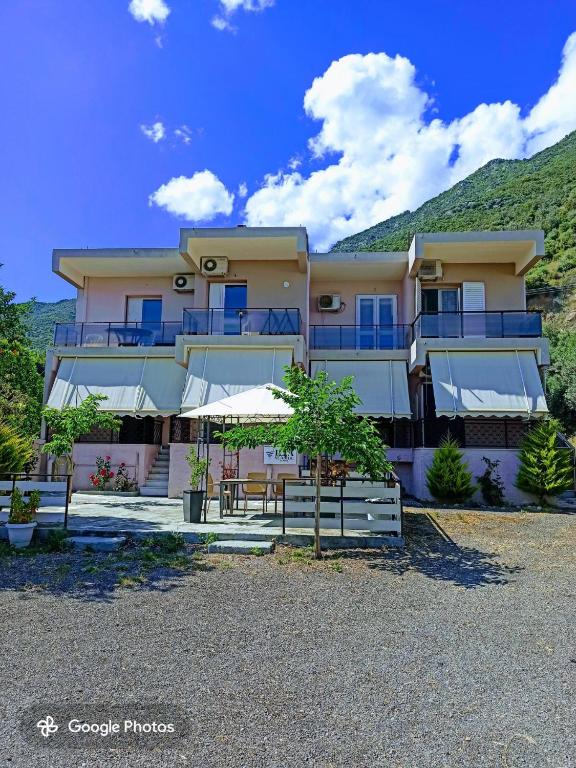 a large apartment building with a mountain in the background at Ilia Sea Side Studios in Ilia