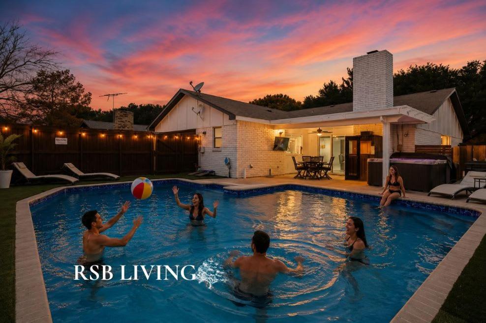 a group of people playing with a ball in a swimming pool at Luxurious 5BR 2BA Holiday Home with Pool, Grill, Sauna & Game Room in The Colony