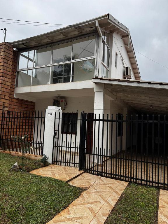a white house with a black fence and window at Raíces Vivas Dúplex - Cochera Privada en Oberá in Oberá