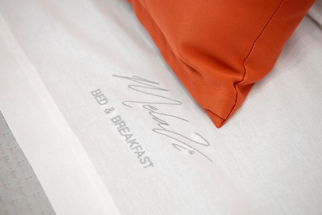 a white shirt with an orange tie on it at B&B Melavì in Lizzano