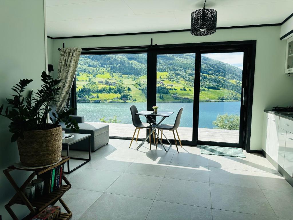 a living room with a table and chairs and a large window at Olden Apartment with Panorama view in Olden