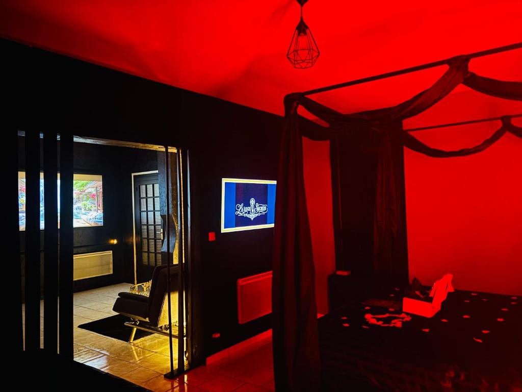 a bedroom with a red ceiling and a bed with a canopy at La loge secrète Love Room in Dolus-le-Sec