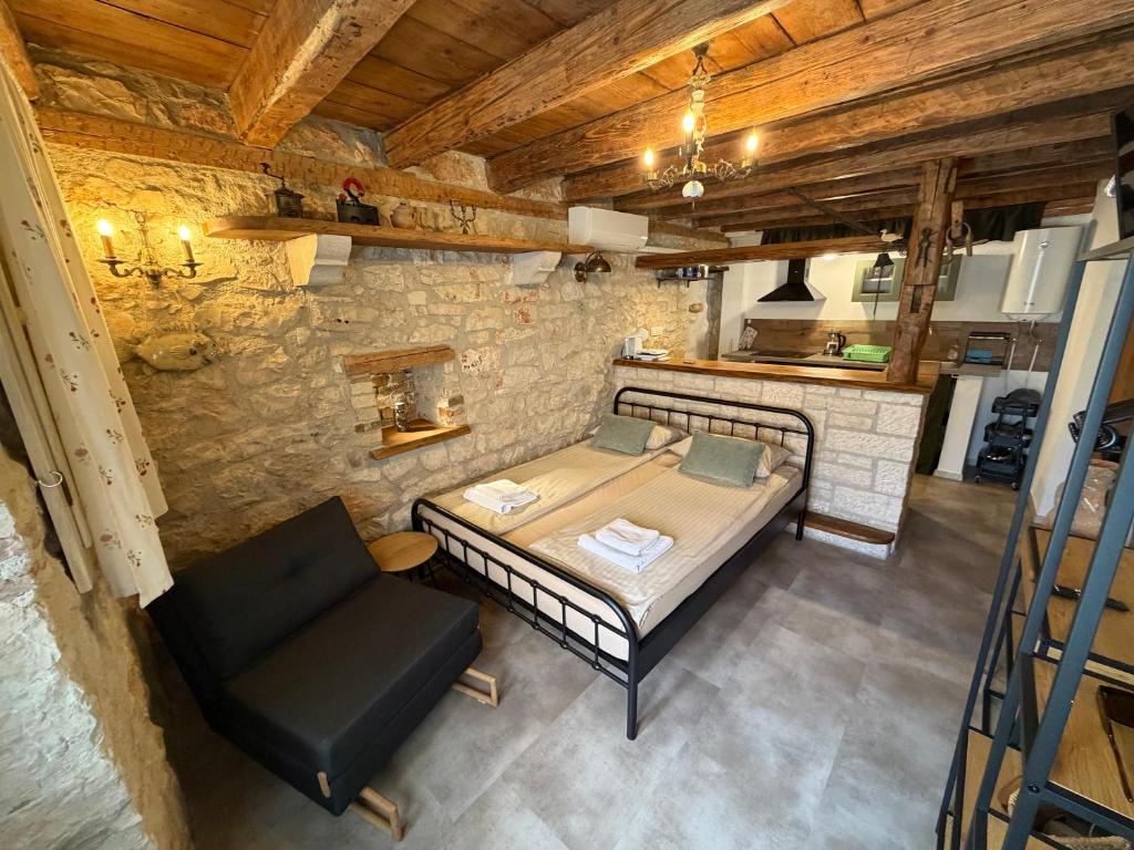 a bedroom with a bed and a chair in a room at Studio apartman Ema in Umag