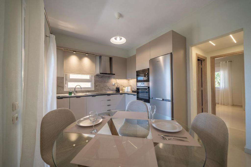 a kitchen with a glass dining table and chairs at Gerania nature Residence 22 in Siátista