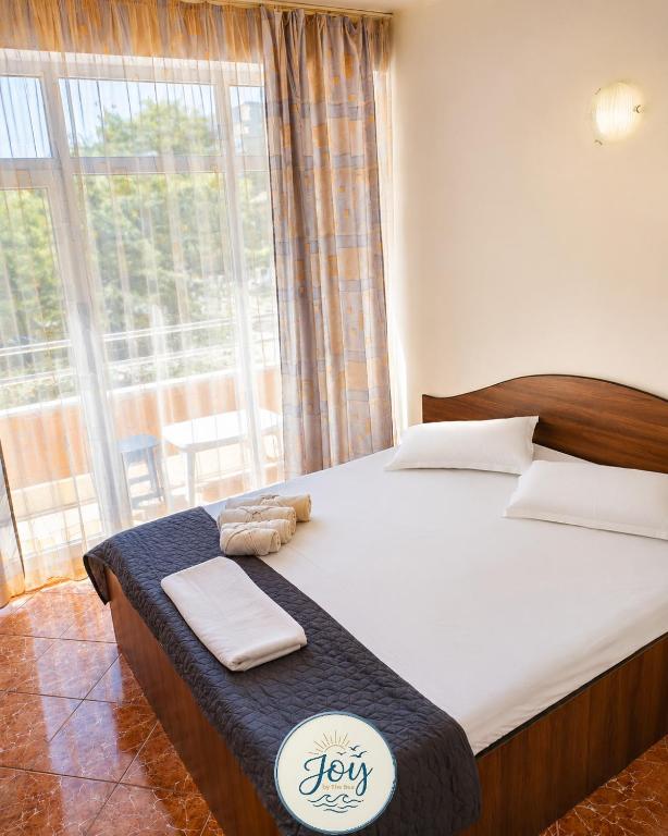 a large bed in a room with a large window at Vila njoy by the sea in Eforie Sud