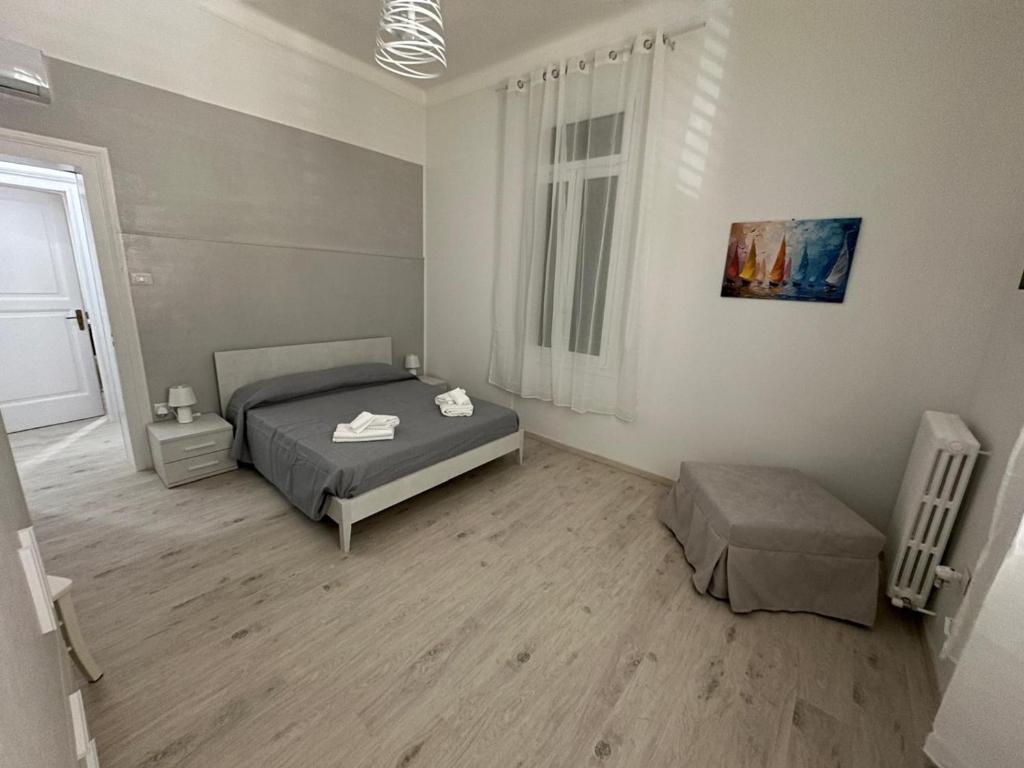 a bedroom with a bed and a chair and a window at Casa Pinuccio Sapri in Sapri
