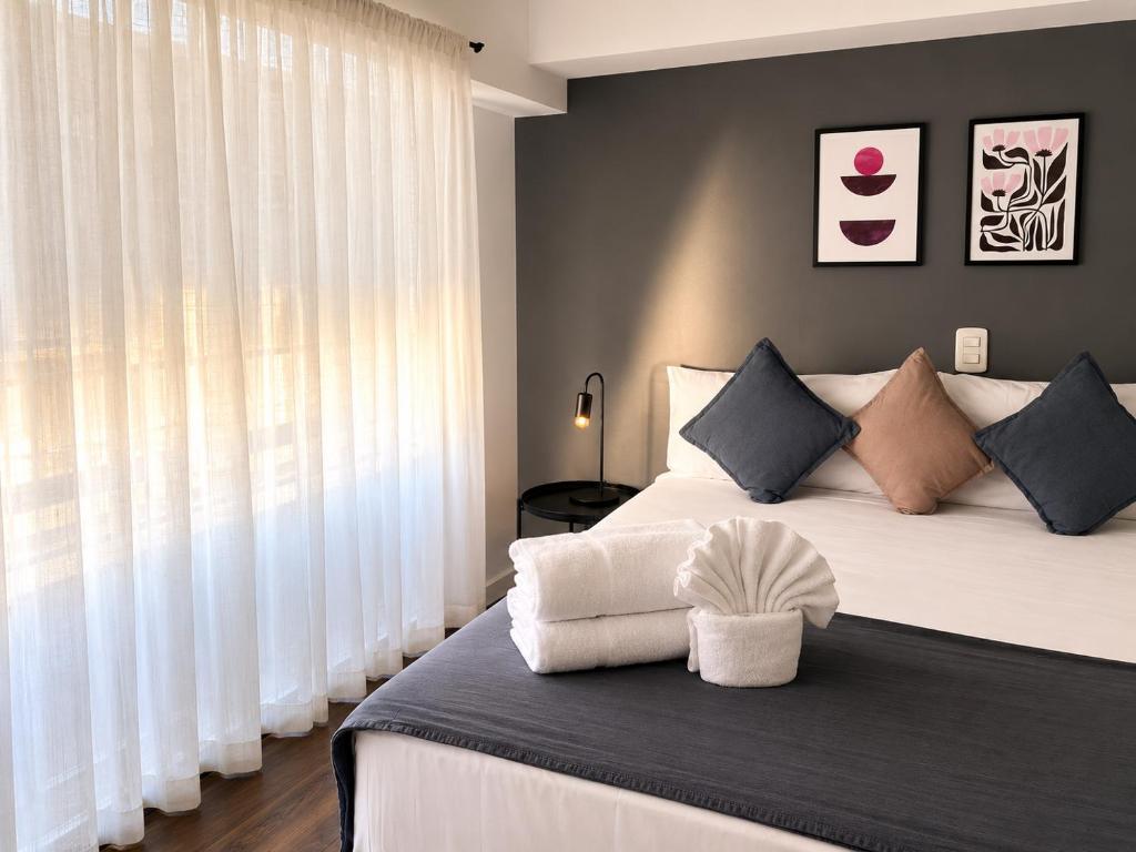 a bedroom with a large bed with white curtains at El Misti Suites Buenos Aires in Buenos Aires