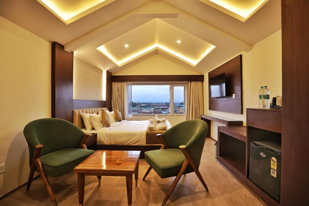 a hotel room with a bed and a table and chairs at Trillium Hotel by Stay Sphere in Srinagar