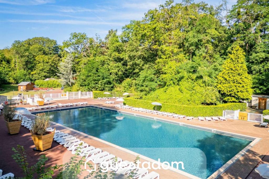 an overhead view of a swimming pool with white chairs and trees at Clairière AC - Petfriendly Piscine in Saint-Chéron