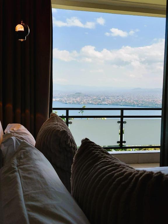 a bedroom with a view of the city from a window at RUBONA HILL Lodge in Gisenyi