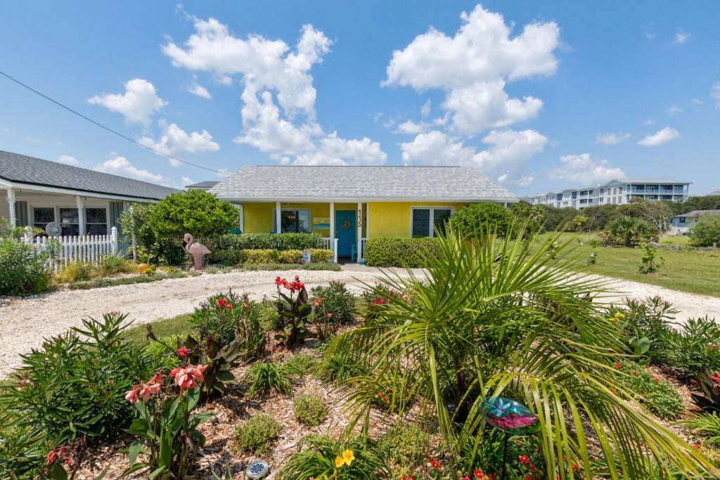a house with a garden with flowers and plants at 115 South Fletcher in Fernandina Beach