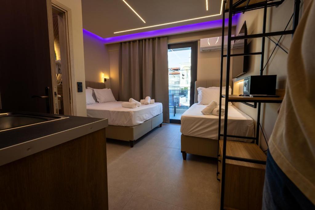 a hotel room with two beds and a sink at Troy Seaside in Paralia Katerinis