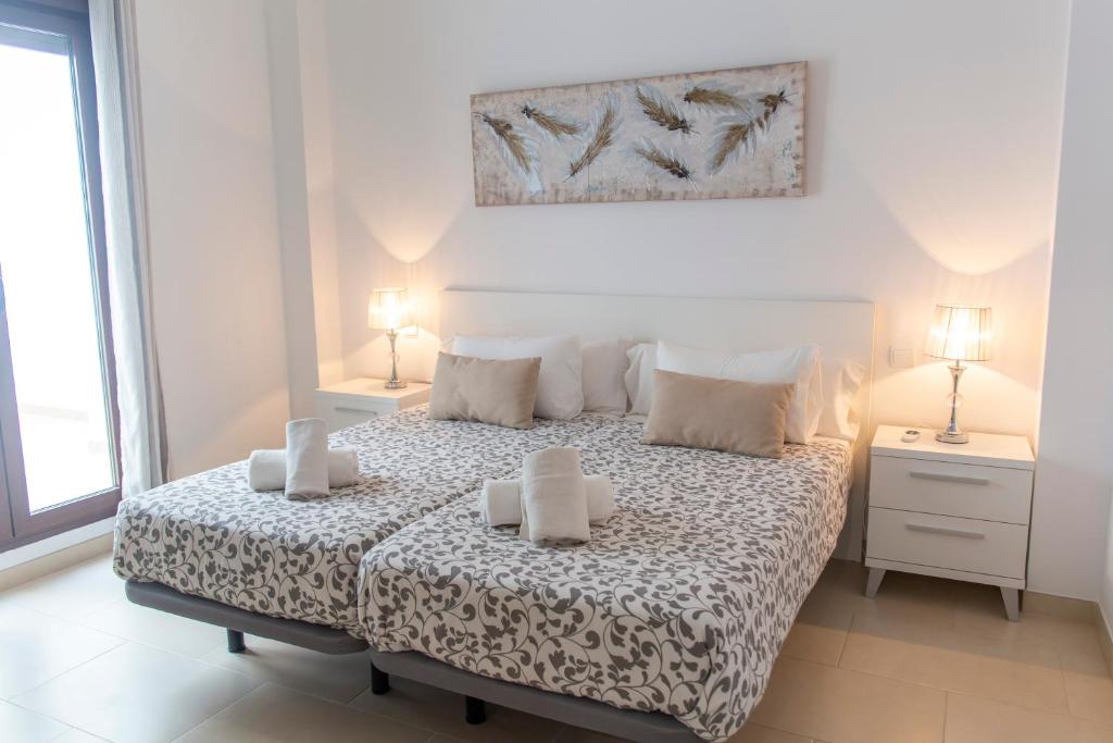 a bedroom with a bed with two candles on it at Royal Suites Estepona by Croma in Estepona