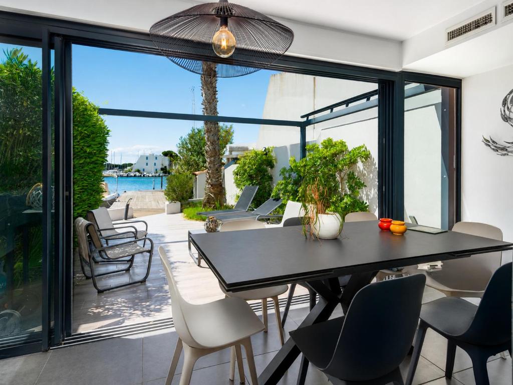 a dining room with a table and chairs on a patio at Villa Marina N173 - 5P6 in Le Grau-du-Roi