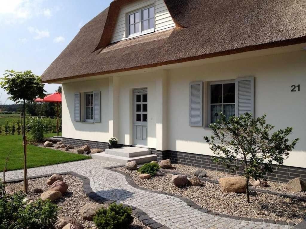 a house with a stone walkway in front of it at Ferienhaus Strandmuschel mit Sauna in Loddin