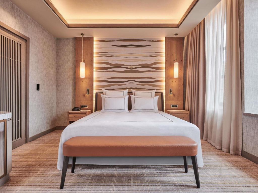 a bedroom with a large bed with white pillows at Swissotel Uludag Bursa in Bursa