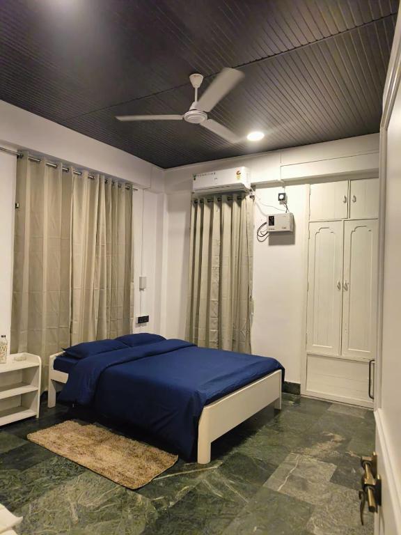 a bedroom with a blue bed and a ceiling at Lighthouse Villa Homestay in Dimapur