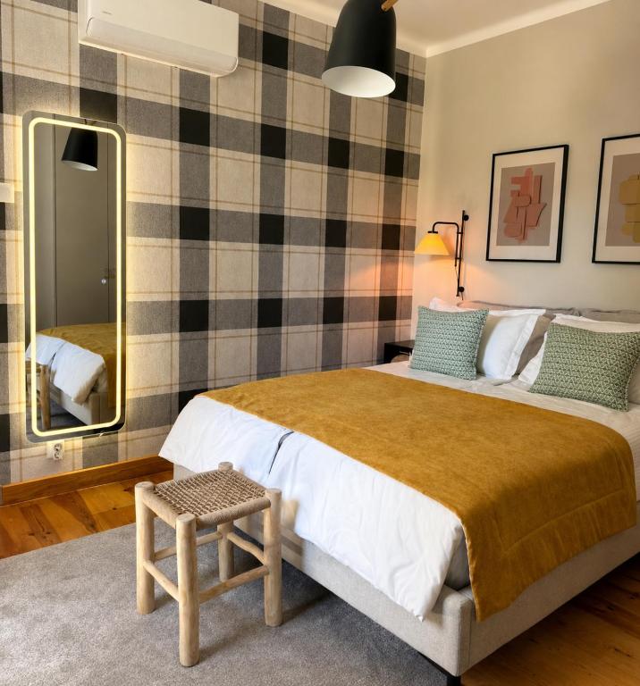 a bedroom with a large bed and a mirror at Casa da Loja in Marinha Grande