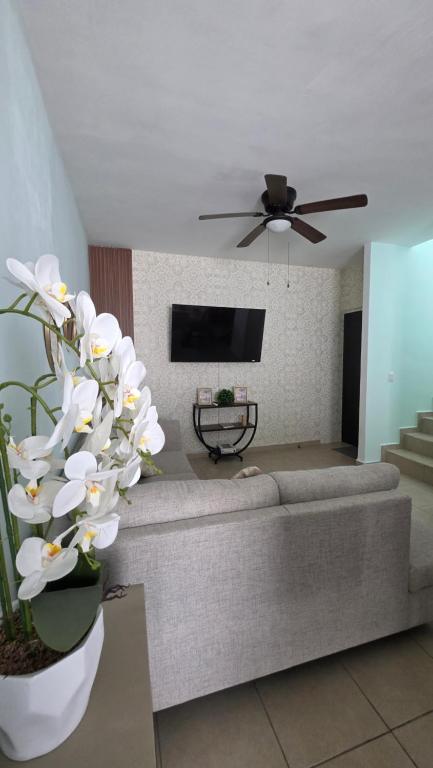 a living room with a couch and a tv at Casa León Cerca del Aeropuerto Internacional y Parques Industriales, Facturamos in Monterrey