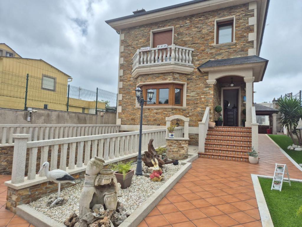 a brick house with a white fence at Casa da Xoiña in Foz