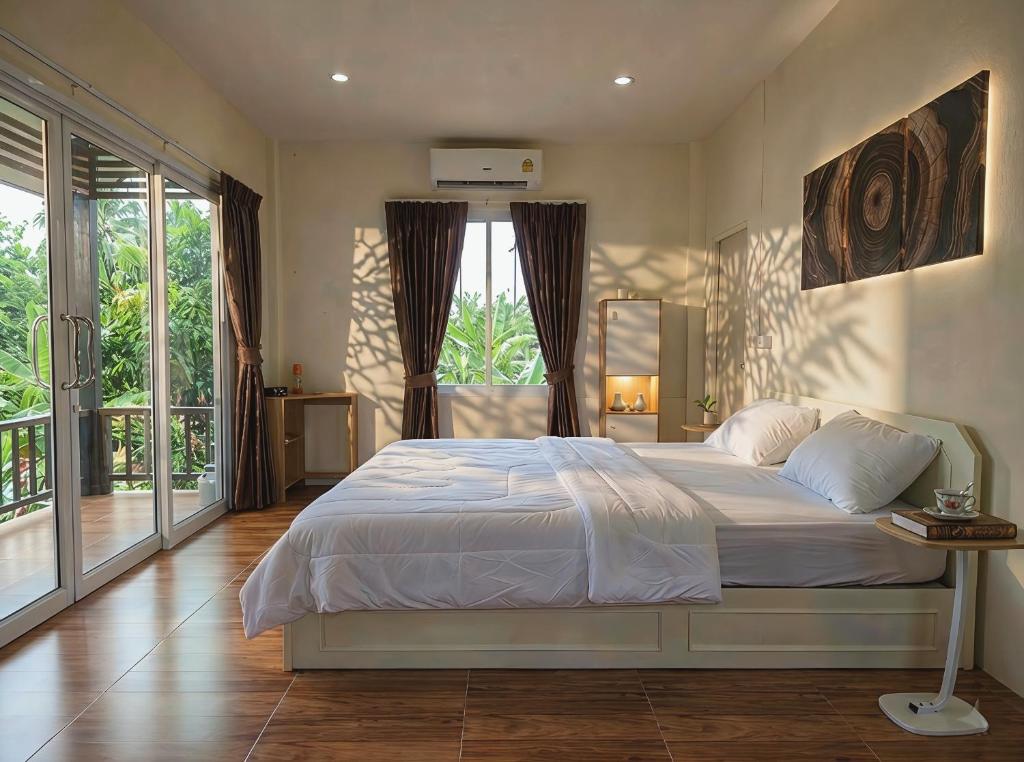 a bedroom with a bed and a large window at Casa Srithanu in Ko Phangan