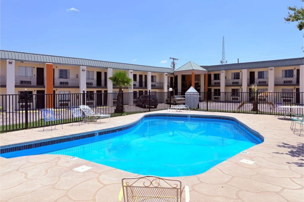 a swimming pool in front of a building at Del Rio Inn TX By Hotel O in Del Rio