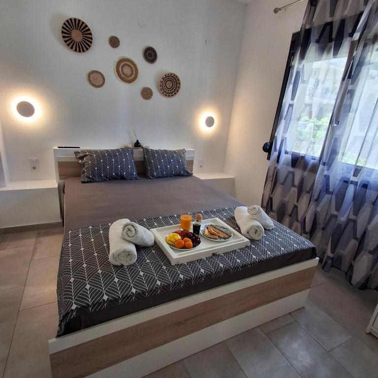 a bedroom with a tray of food on a bed at Sky Rooms in Nea Kallikrateia