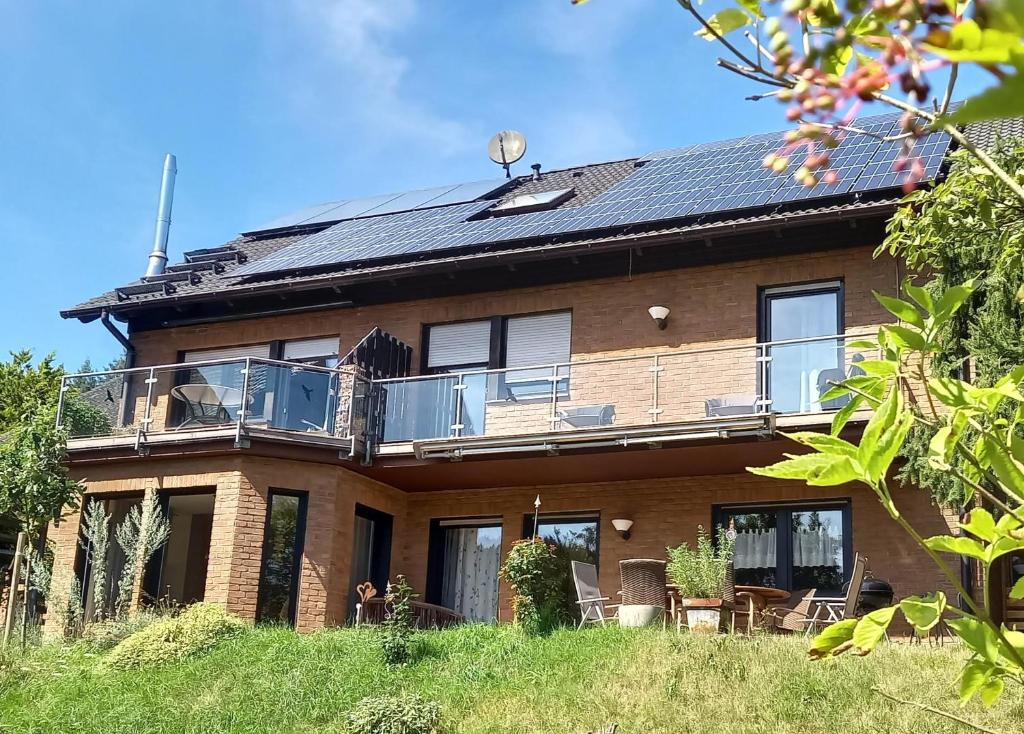 a large brick house with a balcony on top of it at Ferienwohnungen Nibelungenwald in Mossautal