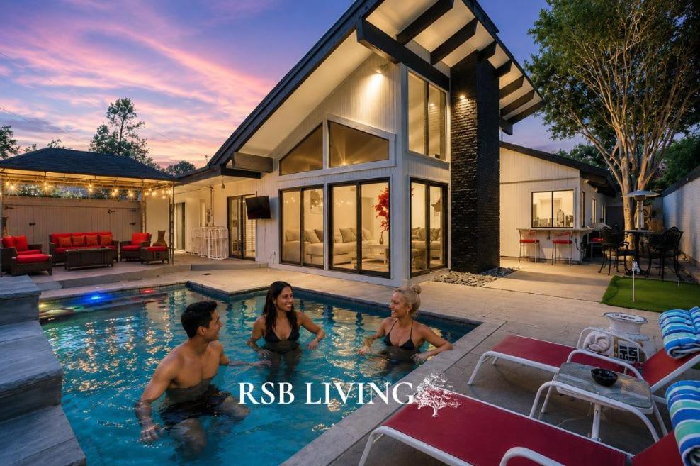 a family in the swimming pool of a house at West Irving Palace Miami Style in Irving