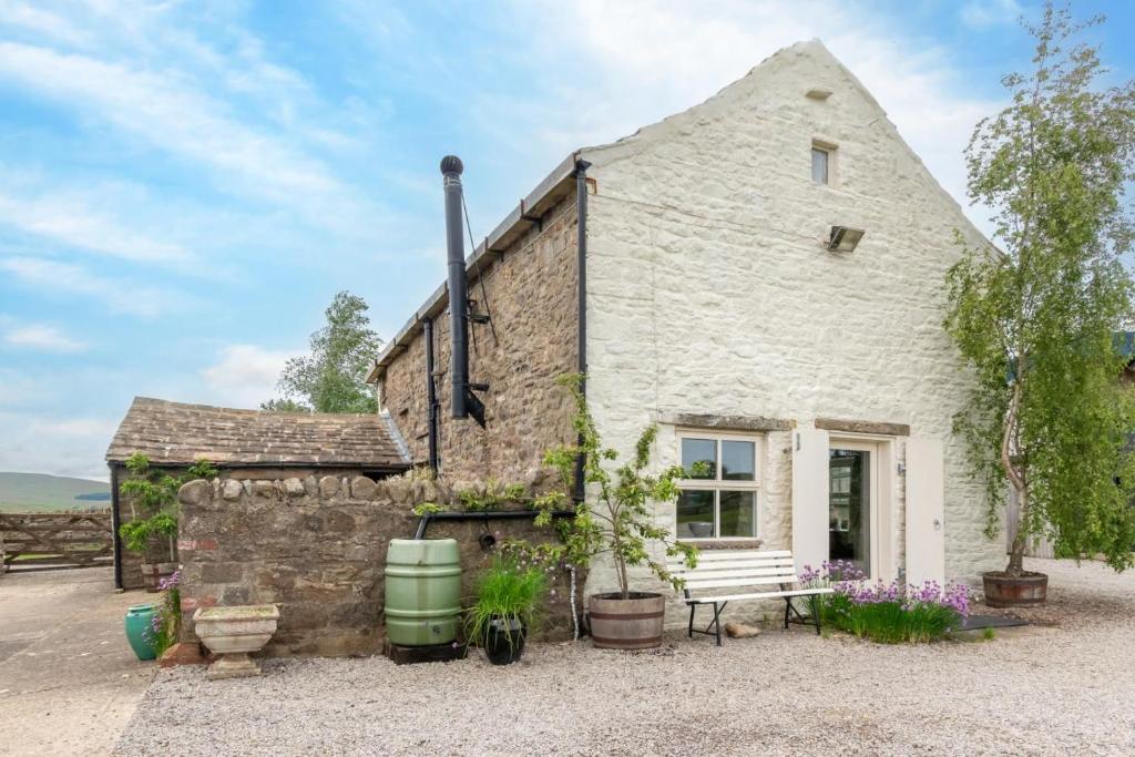 a stone cottage with a bench in front of it at 2 Bed in Bishop Auckland oc-93111 in Westgate