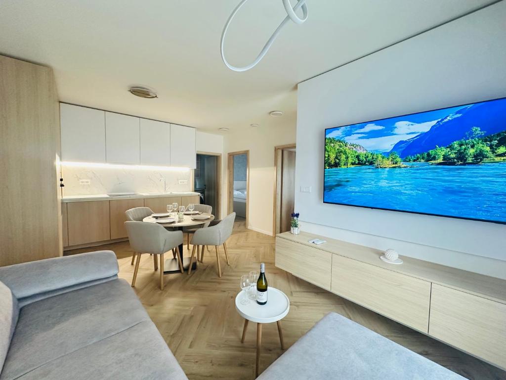 a living room with a large tv on a wall at J&M apartman in Liptovská Teplá